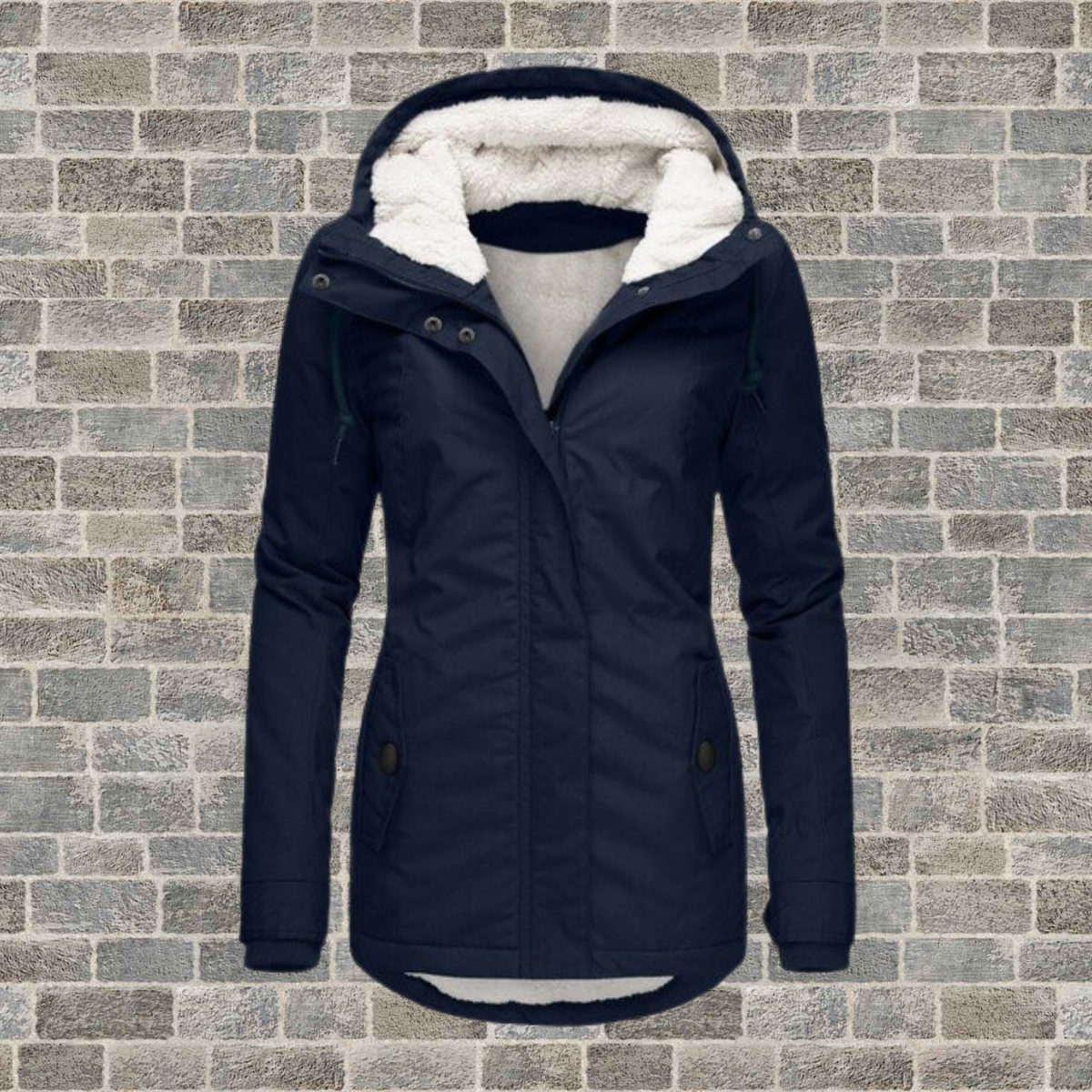 Giacca invernale donna blu scuro con cappuccio foderato in pelliccia sintetica, chiusura a zip, tasche frontali, su sfondo di mattoni grigi.