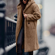 Cappotto teddy bear marrone, donna in strada innevata, moda invernale, cappotto lungo con cappuccio, stile casual chic, abbigliamento caldo.