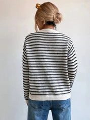Maglione a righe bianche e nere, donna, maniche lunghe, stile casual, indossato con jeans blu. Look autunnale, moda femminile, retro.