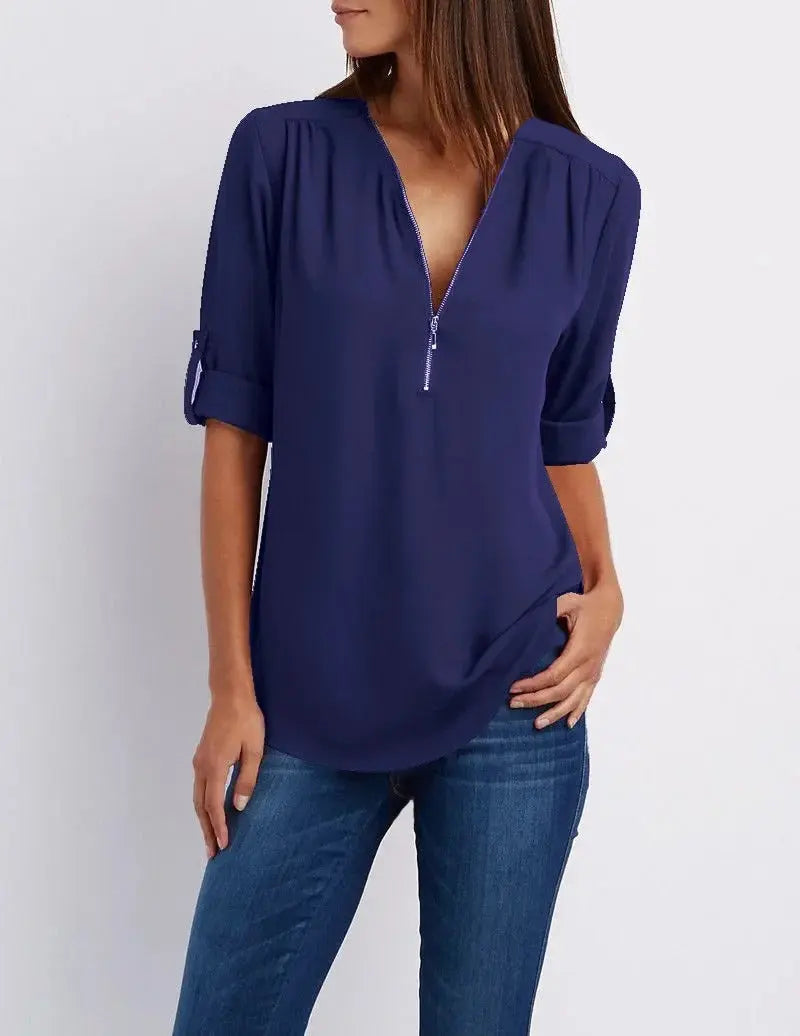 Blusa donna blu con zip, maniche a 3/4, scollo a V, abbinata a jeans. Elegante e casual, perfetta per ogni occasione.