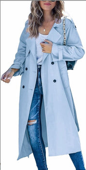 Donna con cappotto trench azzurro, jeans strappati e borsa a catena. Moda autunnale, abbigliamento casual elegante.