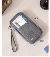 Custodia da viaggio grigia 23x13 cm con cerniera e cinturino, ideale per documenti e biglietti. Accessorio pratico ed elegante per viaggiatori.