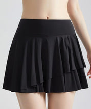 Gonna nera a pieghe, corta, indossata da una persona. Moda femminile, abbigliamento estivo, stile casual elegante.