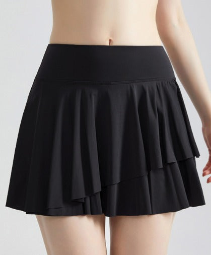Gonna nera a pieghe, corta, indossata da una persona. Moda femminile, abbigliamento estivo, stile casual elegante.