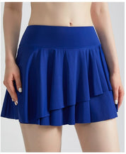 Gonna sportiva blu a pieghe indossata da una donna, moda fitness, abbigliamento atletico, tessuto leggero, stile casual, abbigliamento estivo.