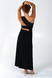 Donna in abito lungo nero elegante, schiena scoperta, in posa di profilo. Moda femminile, abbigliamento da sera, stile sofisticato.