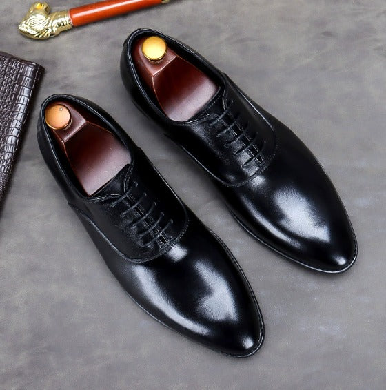 Scarpe eleganti da uomo in pelle nera, stile Oxford, con lacci. Accessorio di moda classico su sfondo grigio. Ideali per abbigliamento formale.