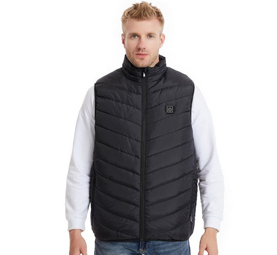 Giubbotto nero imbottito da uomo, senza maniche, con zip frontale. Indossato sopra una felpa bianca. Moda casual autunnale.