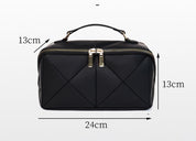 Borsa da viaggio nera in pelle con cerniera dorata, manico superiore, design trapuntato, dimensioni 24x13x13 cm. Elegante e compatta.