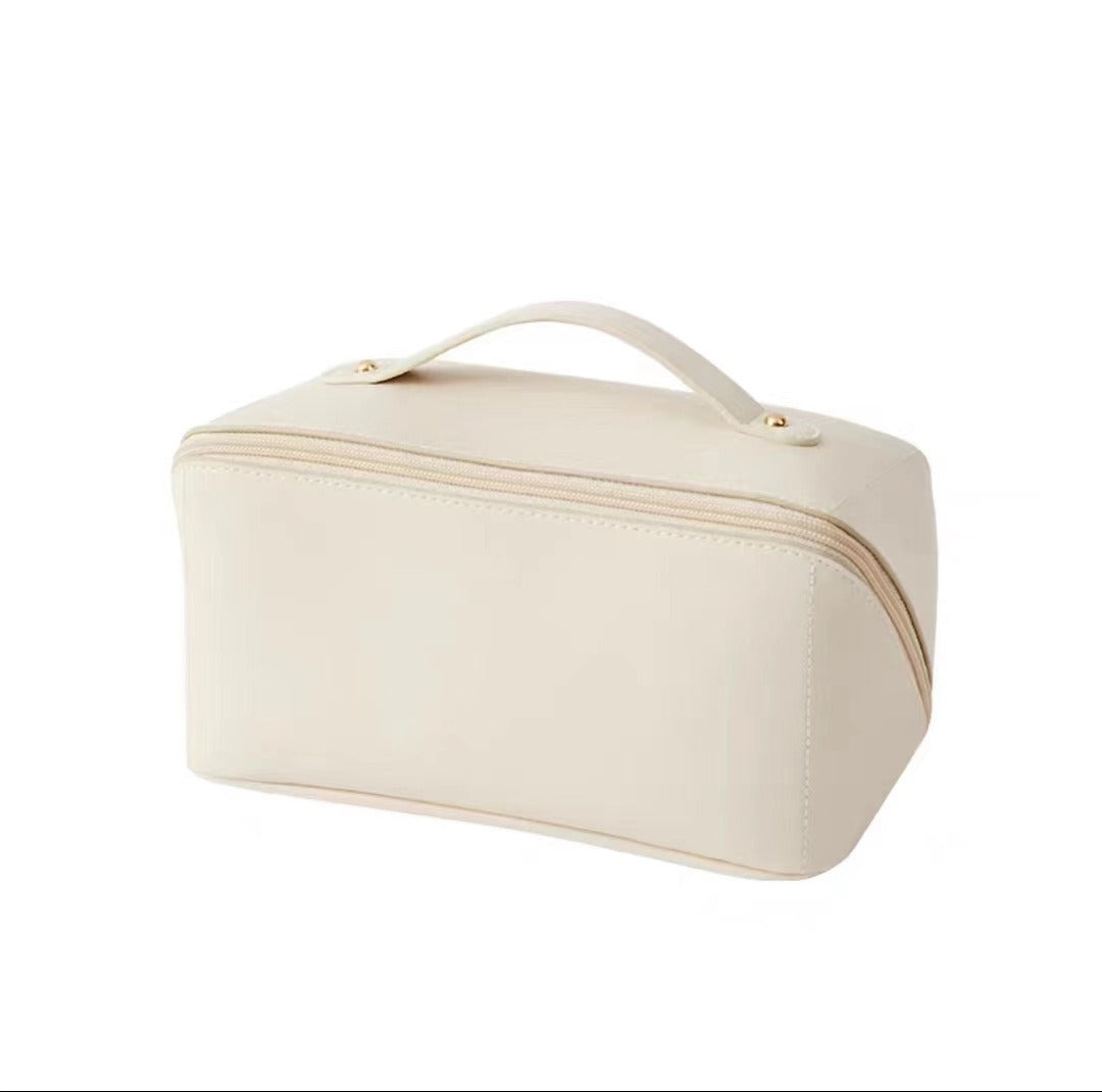 Beige leather makeup bag with handle and zipper closure, ideal for travel and cosmetics storage. Sleek, minimalist design for organized beauty essentials.