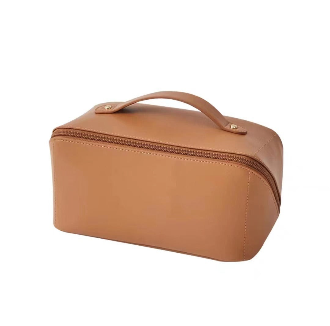 Tan leather toiletry bag with zipper and handle, ideal for travel. Compact, stylish design for organizing personal care items.