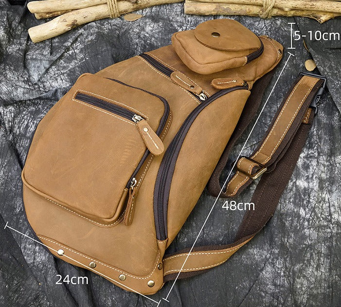 Zaino a tracolla in pelle marrone con tasche multiple e cerniere, dimensioni 48x24 cm, ideale per escursioni e viaggi. Design robusto e pratico.