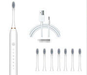Spazzolino elettrico bianco con testine di ricambio, cavo USB per ricarica. Design moderno, set completo per igiene orale avanzata.