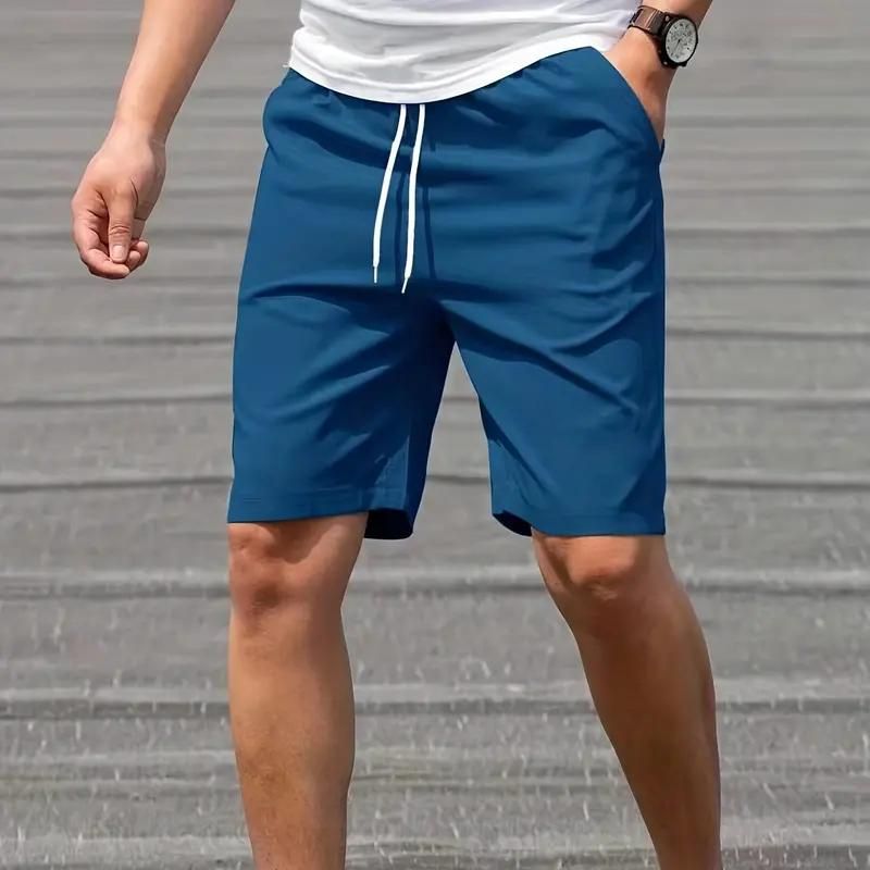 Uomo in pantaloncini sportivi blu con coulisse, indossa una maglietta bianca e orologio. Moda casual estiva, abbigliamento maschile comodo.