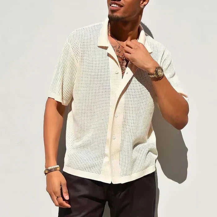 Camicia estiva uomo in maglia traforata beige, maniche corte, abbinata a pantaloni scuri. Stile casual elegante, ideale per moda estiva.