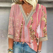Blusa donna rosa con paillettes dorate, scollo a V in pizzo, maniche a tre quarti, abbinata a jeans. Moda femminile elegante e casual.