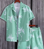 Completo estivo uomo verde menta con palme, camicia a maniche corte e pantaloncini coordinati, perfetto per look casual e vacanze al mare.