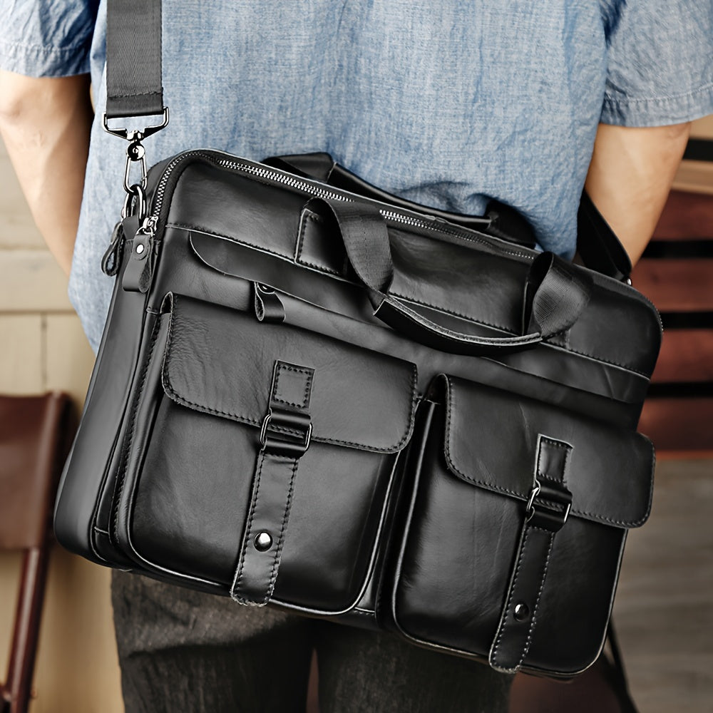 Borsa a tracolla in pelle nera per uomo, con tasche multiple e chiusure a fibbia, indossata su camicia blu. Elegante e funzionale per lavoro.