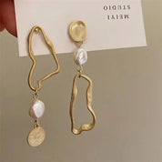Orecchini pendenti asimmetrici in oro con perle irregolari e moneta, design moderno, gioielli artigianali eleganti, accessori moda donna.