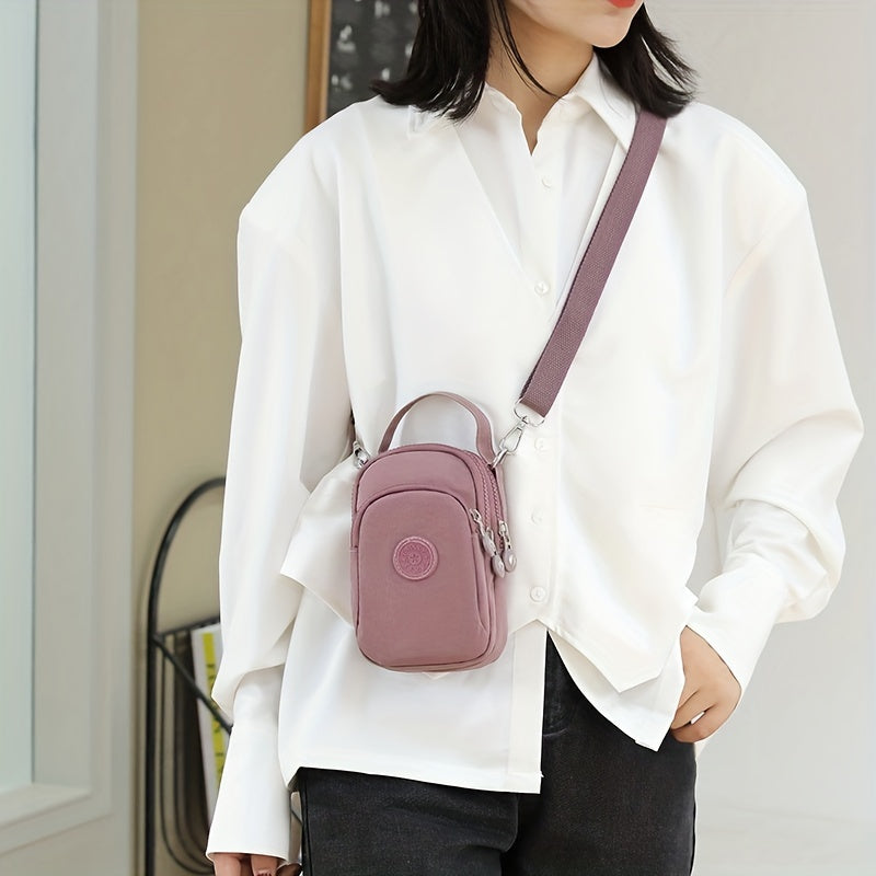 Donna con camicia bianca indossa borsa a tracolla rosa, piccola e compatta, ideale per moda casual. Accessorio trendy per look quotidiano.