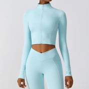 Donna in abbigliamento sportivo azzurro, top a maniche lunghe e leggings coordinati. Moda fitness, abbigliamento palestra, stile athleisure.