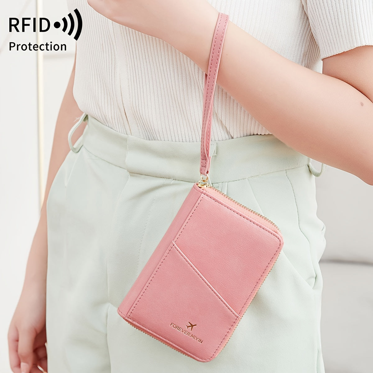 Portafoglio rosa con protezione RFID, design compatto, chiusura a zip, cinturino da polso, ideale per donna, moda accessori, sicurezza carte.