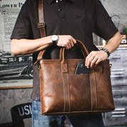 Uomo con borsa a tracolla in pelle marrone, orologio al polso, smartphone in tasca. Elegante accessorio moda maschile.