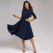 Abito elegante blu scuro da donna, maniche a tre quarti, gonna svasata, cintura in vita, perfetto per eventi formali e serate speciali.