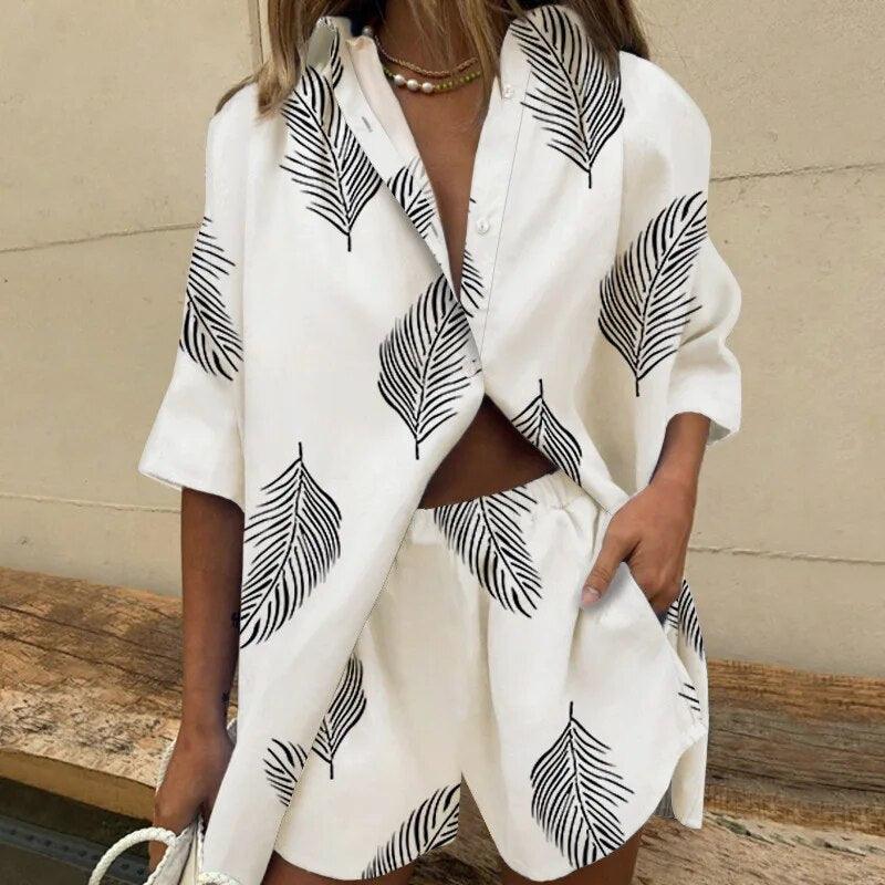 Donna con completo estivo bianco a foglie nere, camicia e shorts coordinati. Moda casual, abbigliamento estivo, stile trendy.