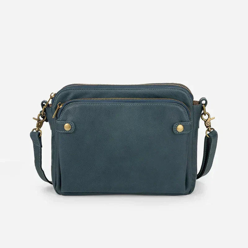 Borsa a tracolla in pelle blu scuro con cerniere dorate, design elegante e compatto. Accessorio moda donna, ideale per ogni occasione.