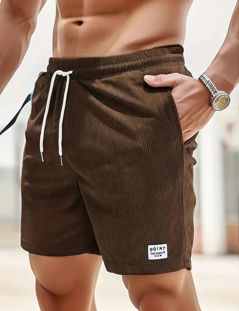 Shorts da uomo marroni in tessuto a coste, con laccio bianco in vita e tasche laterali. Ideali per moda estiva e casual.