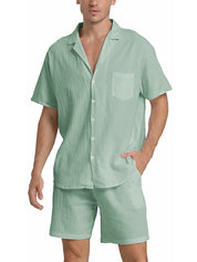 Uomo in completo estivo verde menta, camicia a maniche corte e pantaloncini coordinati, moda casual estiva, abbigliamento leggero e traspirante.