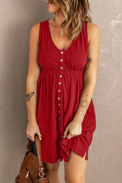 Donna in abito rosso estivo con bottoni, tatuaggi visibili su braccio, borsa marrone. Moda femminile casual, abbigliamento estivo elegante.