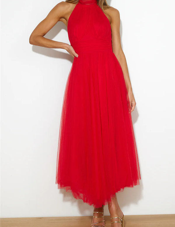 Abito lungo rosso elegante in tulle, senza maniche, con collo alto. Perfetto per eventi serali. Donna in sandali dorati. Moda femminile chic.
