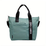 Borsa a tracolla verde acqua con manici neri, tasca frontale e scritta "EVES CAMIER". Design moderno, ideale per moda donna e shopping.