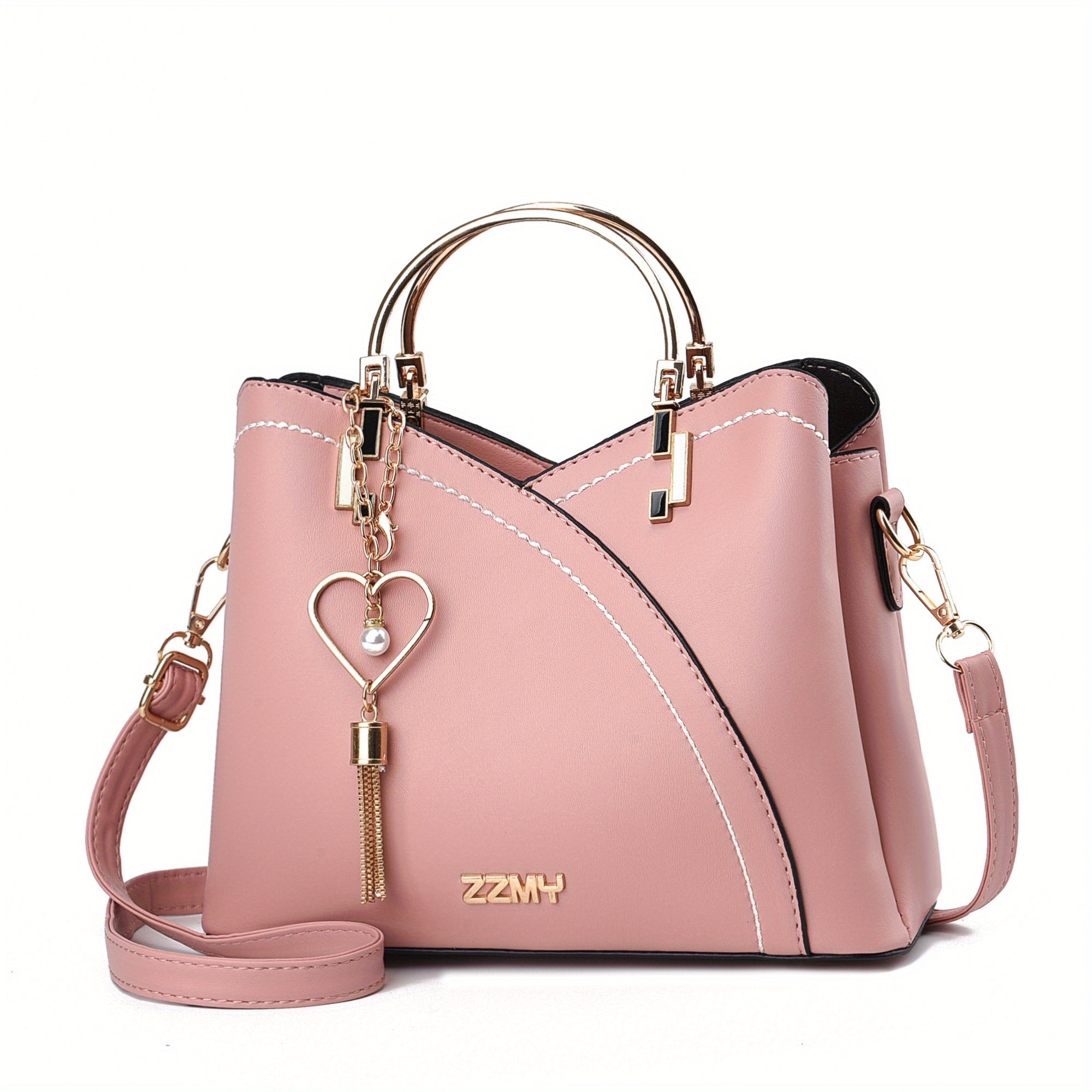 Borsa a mano rosa in pelle con manici dorati, tracolla regolabile e ciondolo a cuore. Design elegante, ideale per moda femminile e accessori di lusso.