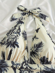 Costume da bagno intero donna con stampa tropicale, scollo all'americana, fondo bianco e motivi blu navy. Elegante e ideale per l'estate.