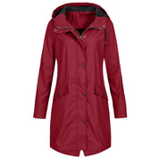 Giacca impermeabile donna rossa con cappuccio, chiusura a bottoni, tasche frontali. Elegante e funzionale per pioggia e outdoor.