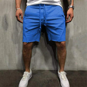 Shorts uomo blu, casual, con coulisse, indossati con scarpe sportive bianche. Ideali per moda estiva, abbigliamento casual, comfort quotidiano.
