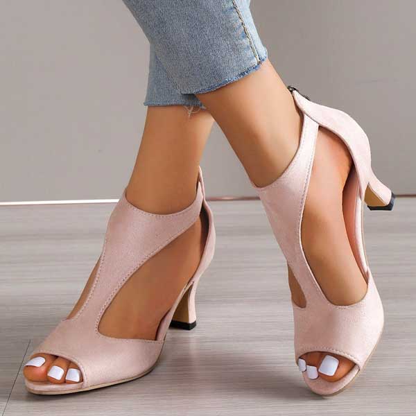Sandali eleganti rosa con tacco medio, design aperto, indossati con jeans chiari. Scarpe da donna alla moda per occasioni speciali.