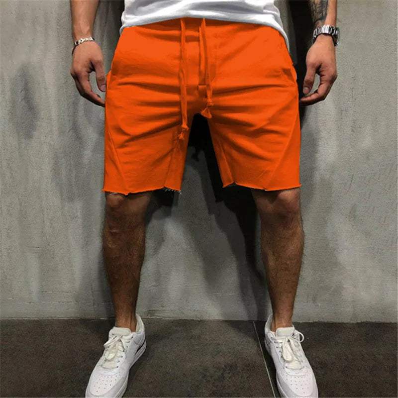 Shorts arancioni da uomo, casual, con coulisse, indossati con scarpe da ginnastica bianche. Ideali per l'estate e il tempo libero.