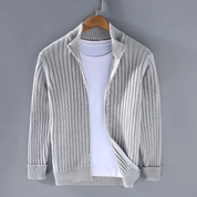 Cardigan grigio a coste su gruccia, abbinato a t-shirt bianca. Moda uomo, abbigliamento casual, maglione leggero, stile autunnale.