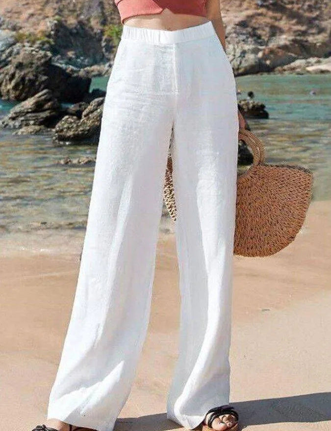 Pantaloni bianchi larghi in lino, donna, moda estiva, spiaggia, con borsa di paglia, look casual chic, abbigliamento leggero e traspirante.