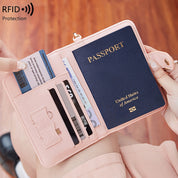 Portafoglio da viaggio rosa con protezione RFID, contenente passaporto USA e carte di credito. Accessorio elegante e sicuro per viaggiatori.