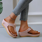 Sandali platform rosa con cinturino regolabile, suola in gomma beige, indossati con jeans aderenti. Scarpe estive moda donna, comode e trendy.