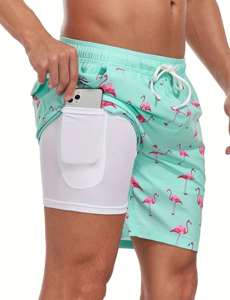 Costume da bagno uomo verde acqua con fenicotteri rosa, tasca laterale per smartphone, design moderno, perfetto per spiaggia e piscina.