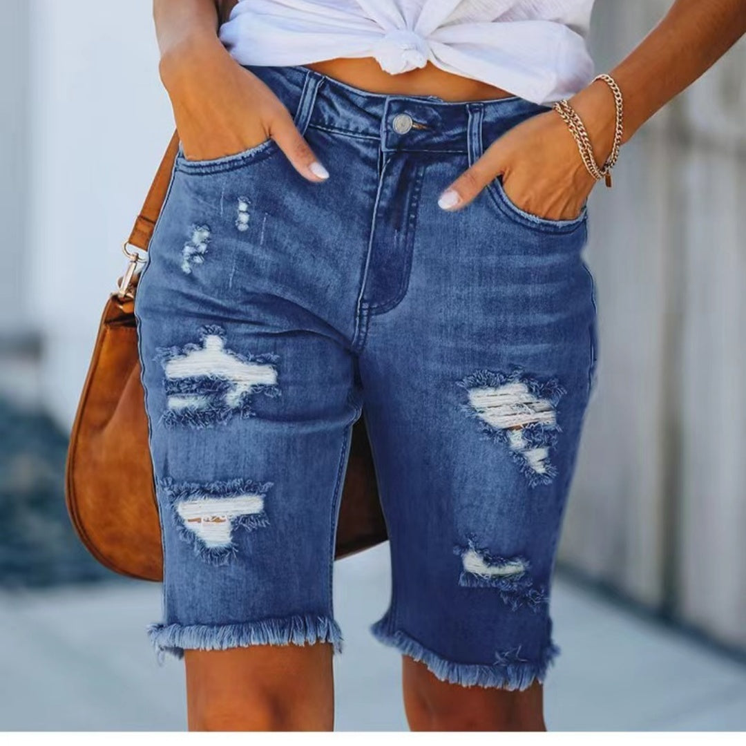 Shorts di jeans strappati da donna, blu, con orlo sfrangiato. Design casual, perfetti per l'estate. Tasche anteriori, chiusura con bottone.
