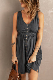 Abito estivo grigio scuro senza maniche con bottoni, indossato da donna con tatuaggi. Stile casual, perfetto per giornate calde.
