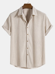 Camicia beige a maniche corte in lino, colletto classico, bottoni frontali, stile casual estivo. Ideale per moda uomo, abbigliamento leggero.