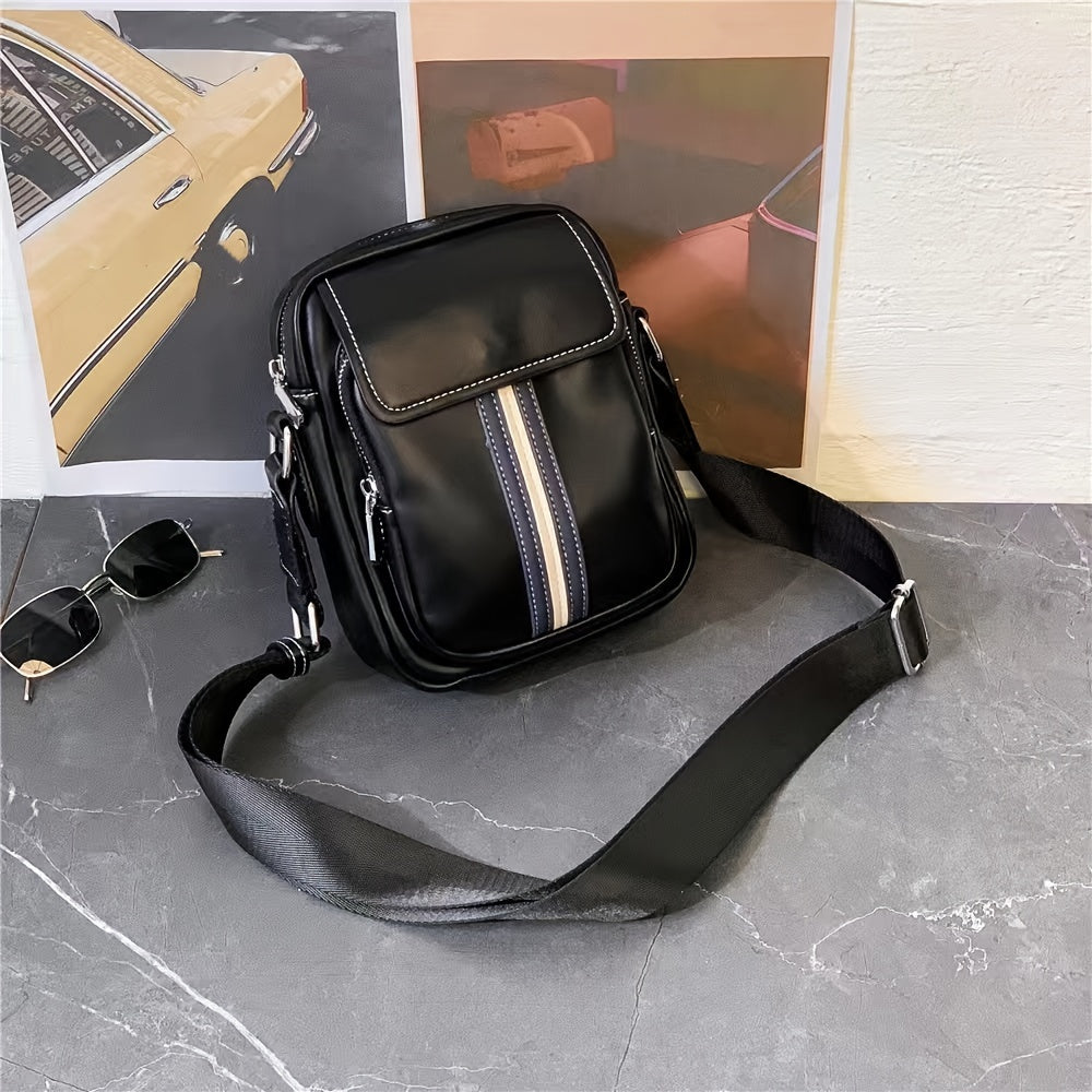 Borsa a tracolla nera in pelle con striscia centrale, design moderno, su sfondo grigio. Accessorio moda uomo, elegante e funzionale.